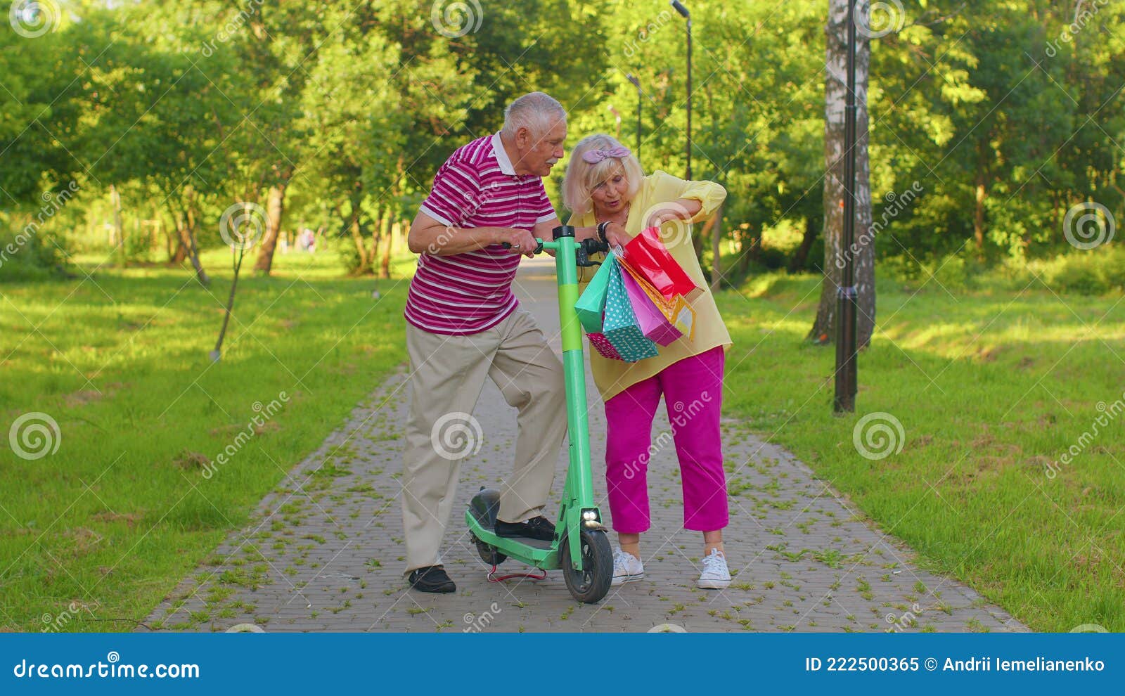 Senior couple walking through a sunny park holding grocery bags, symbolizing retirement and daily living costs