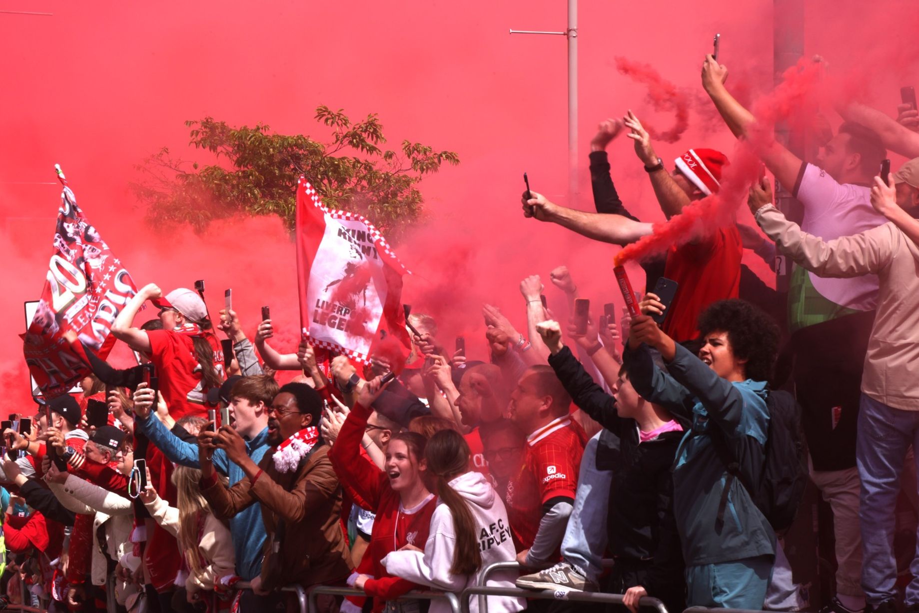A sea of red shirts filling the stands at Anfield stadium with fans cheering during a match
