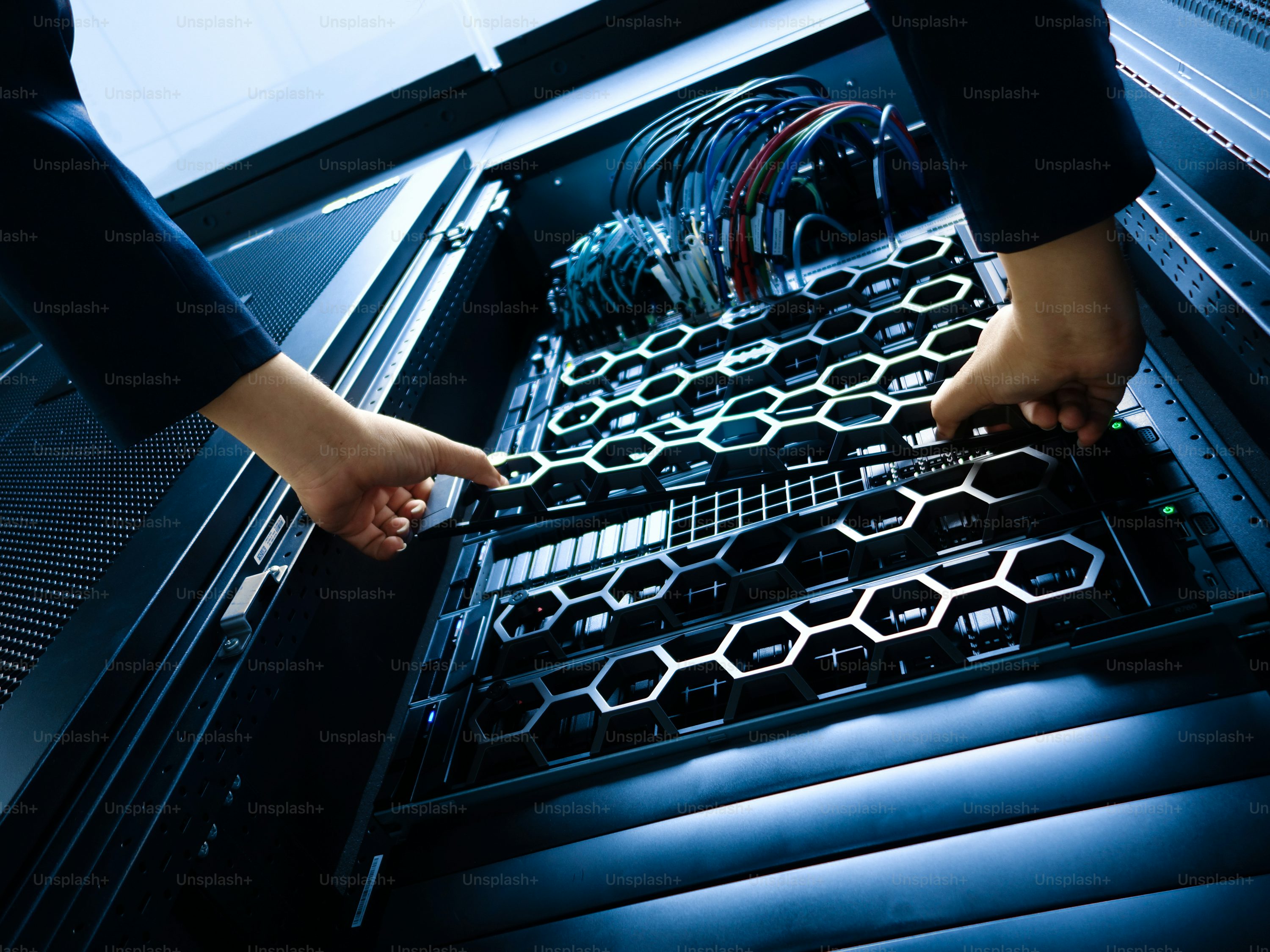 Un technicien en uniforme bleu inspectant des baies de serveurs dans un centre de données sombre aux lumières bleues scintillantes, représentant l'infrastructure de l'intelligence artificiel