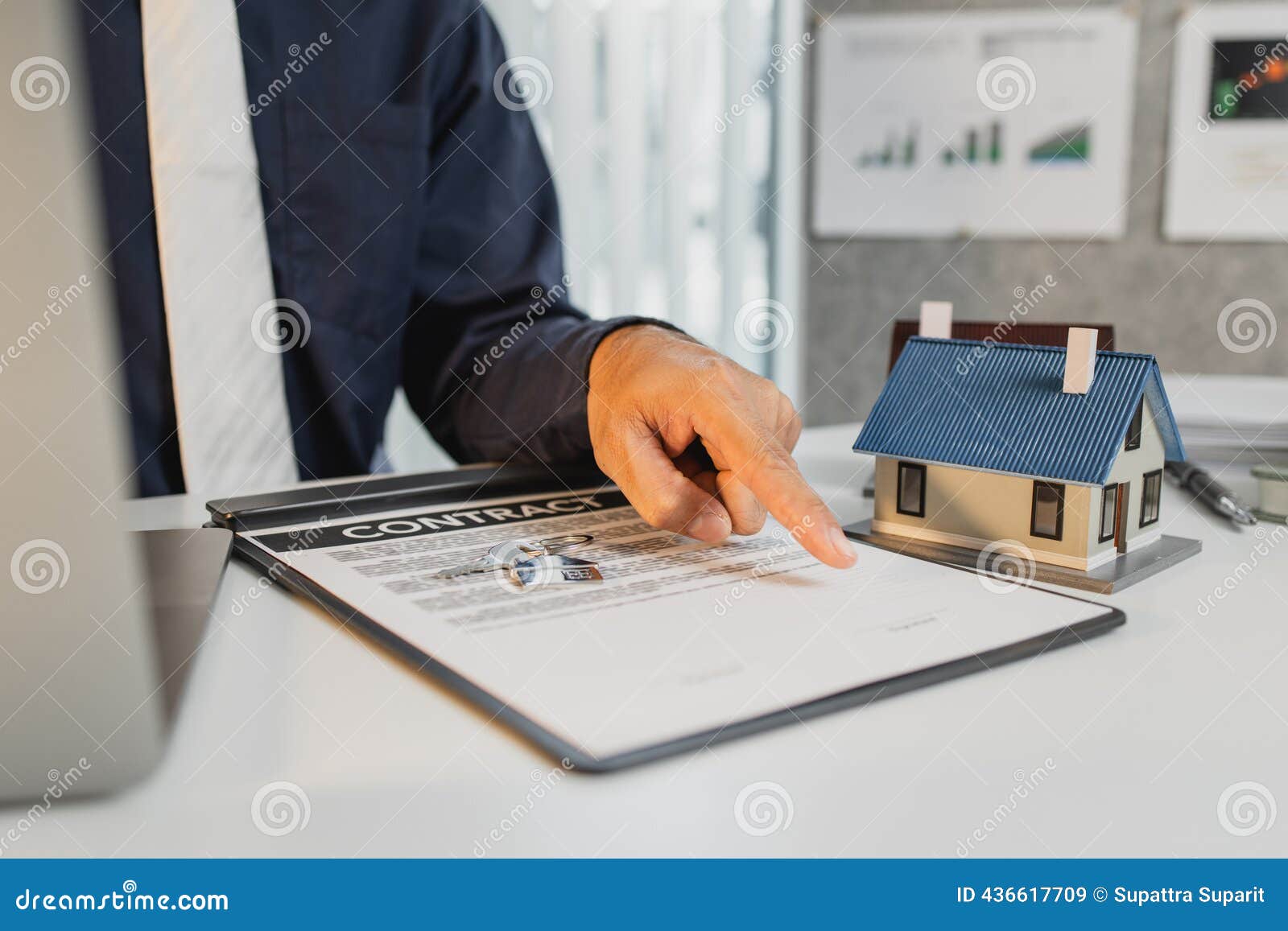 Gros plan sur des documents de prêt hypothécaire, une calculatrice numérique et des clés de maison dorées sur un bureau en bois