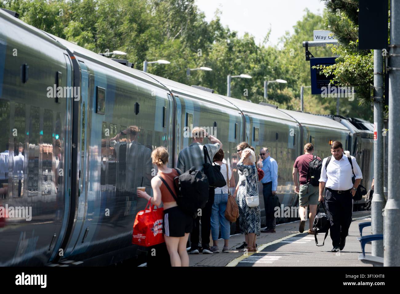 Passengers waiting on a modern Chiltern Railways platform with green and white branding visible in the background