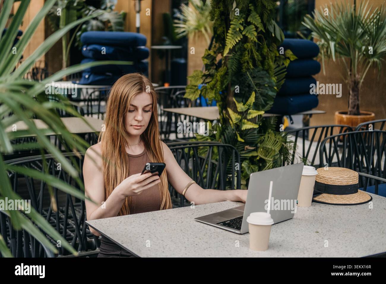 A close-up view of a modern workspace with a laptop and smartphone displaying social media feeds, surrounded by coffee cups and notebooks, capturing the essence of digital content creation.