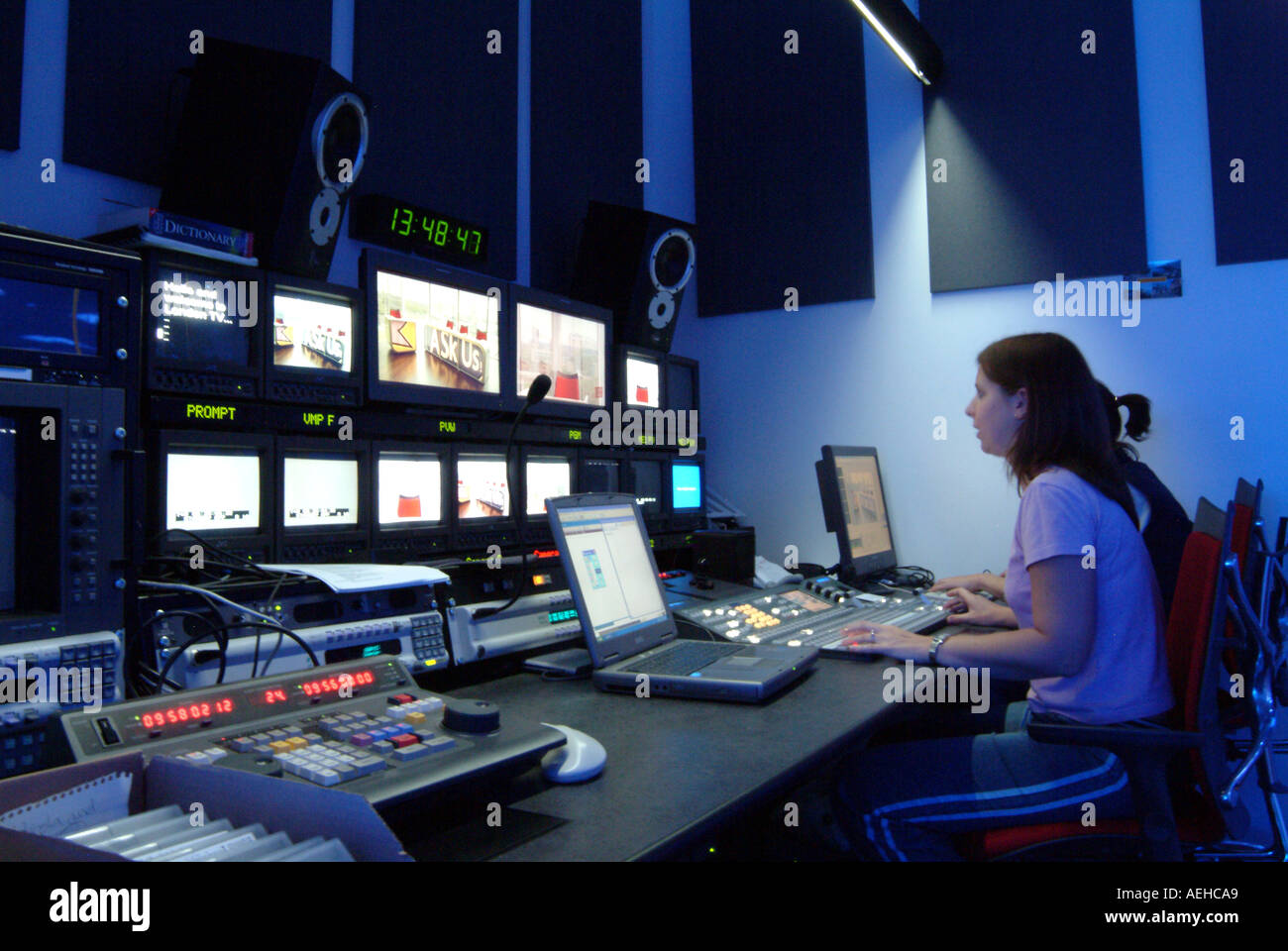 A bustling television studio control room in London with multiple monitors displaying broadcast feeds and a team of producers monitoring the screen.