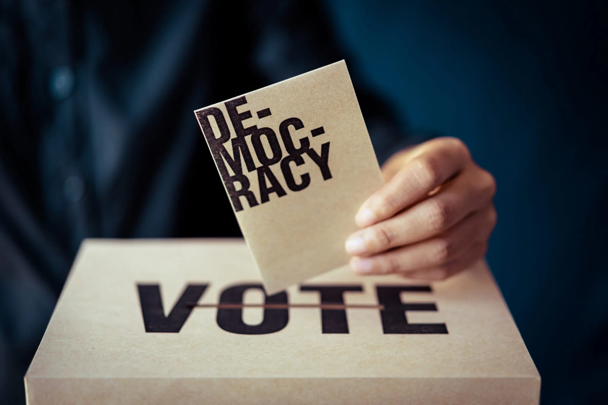 Un gros plan sur une main tenant un stylo au-dessus d'un bulletin de vote, symbolisant la participation civique et l'acte de s'inscrire pour voter.
