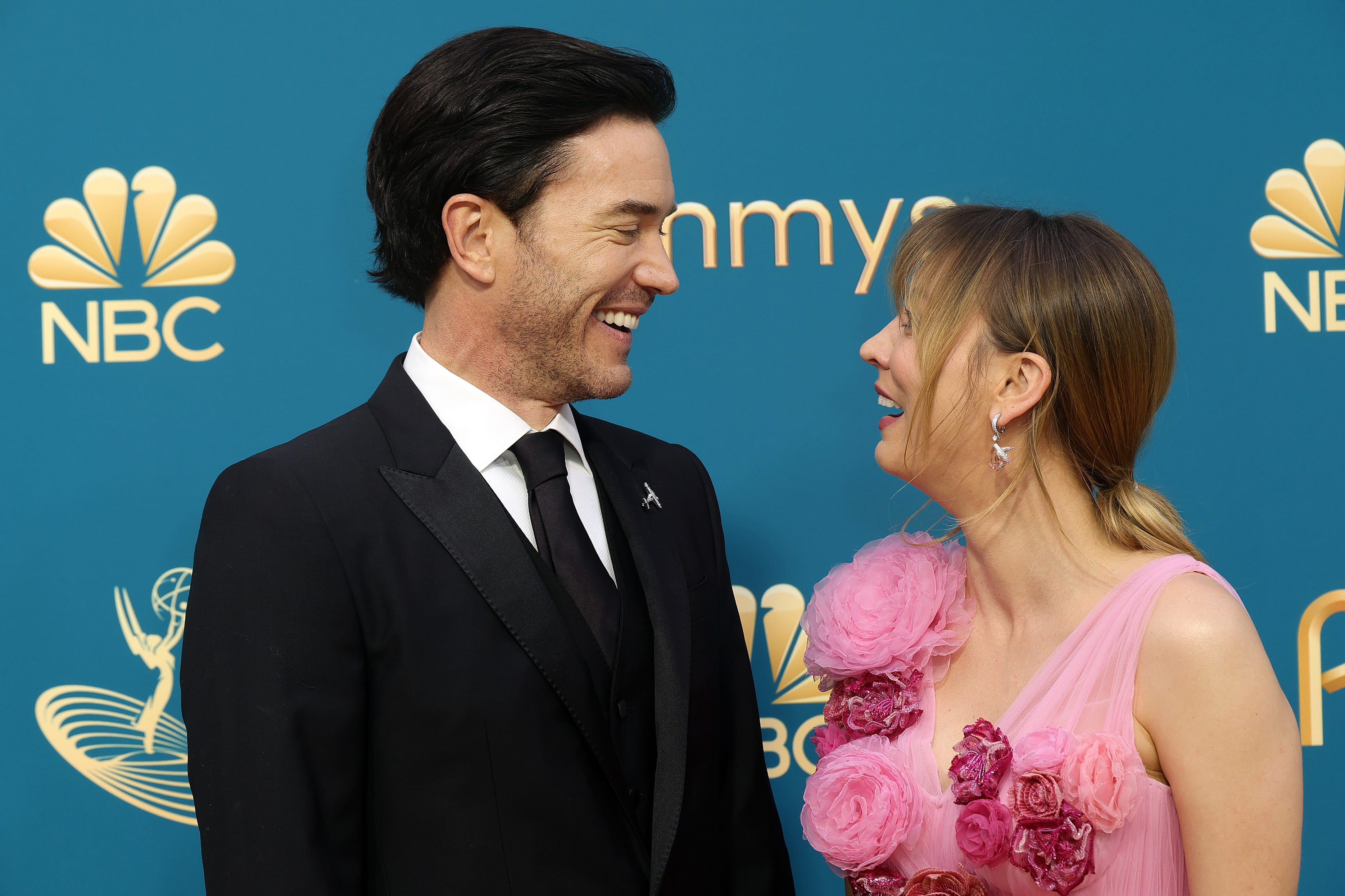 Tom Pelphrey and Kaley Cuoco standing together on a red carpet at a premiere event in Los Angeles